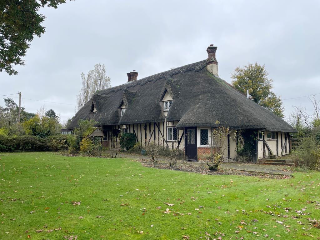 Lot: 31 - A DETACHED THATCHED COTTAGE FOR IMPROVEMENT AND REPAIR - Side angle of Cromwell House taken from the front garden